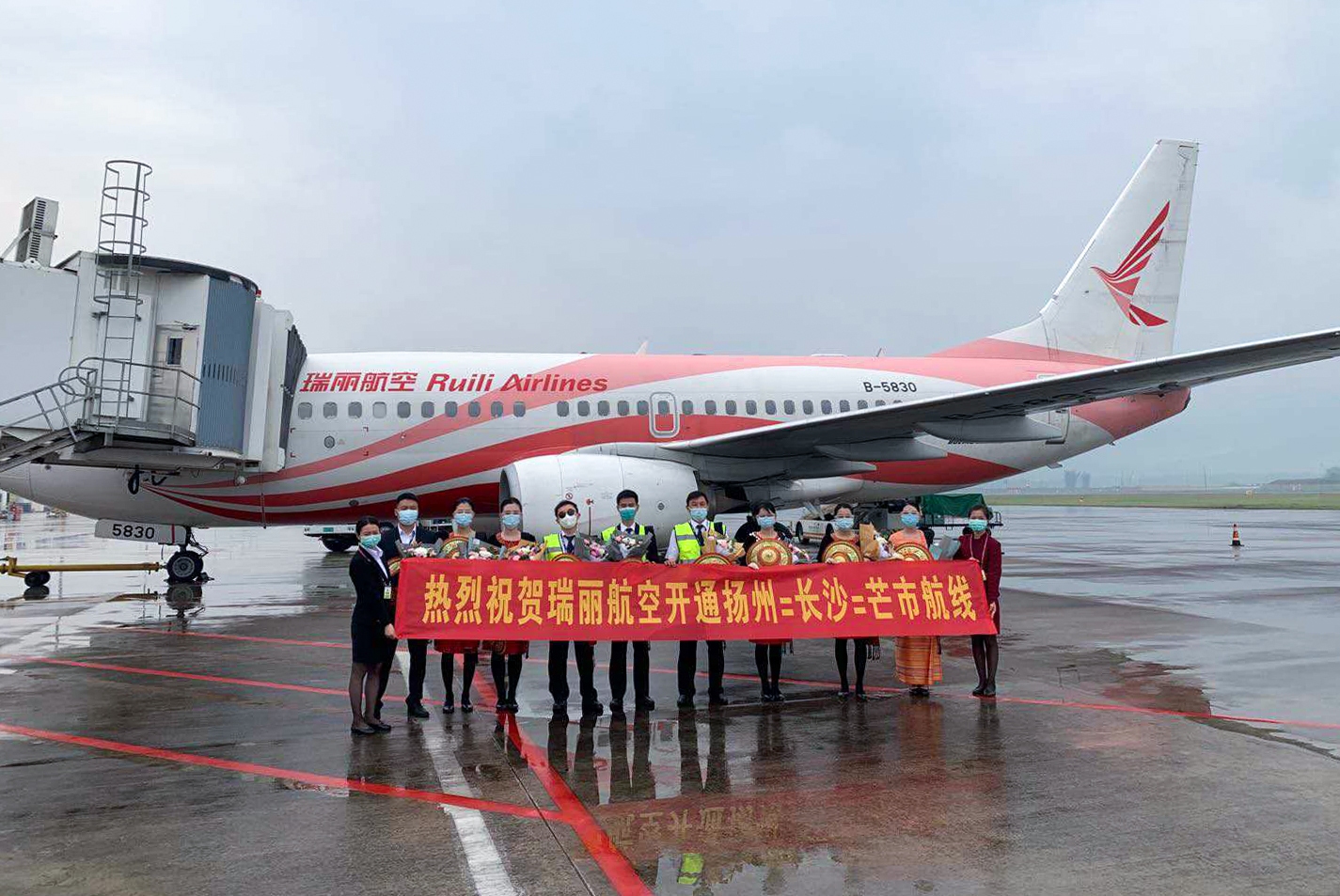 5月4日，瑞丽航空芒市=长沙=扬州首航航班平安降落在扬州机场，首航机组在停机坪上合影